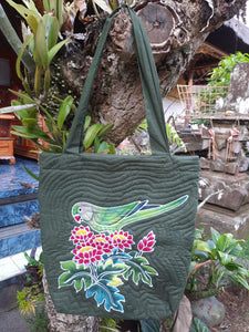 A pale green Indian Ringneck parrot stands in red & yellow flowers with lush foliage. Completely batiked and painted by hand, this is a one-of-a-kind accessory for the IRN lover.
