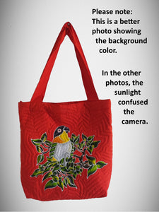 Handpainted batik tote-style bag featuring a Black-headed caique perched among lush foliage, with a reddish background.