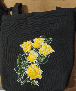 Unique shoulder bag with a bouquet of yellow roses  batiked and painted by hand on a black background, on the front of the bag. The quilting gives a 3D effect. A unique gift for the rose lover in your life!