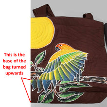 Discounted Sun Conure Handpainted Shoulder Bag because the fabric was cut or sewn incorrectly. As a result, part of the bird's lower wing and vegetation are on the bottom of the bag.