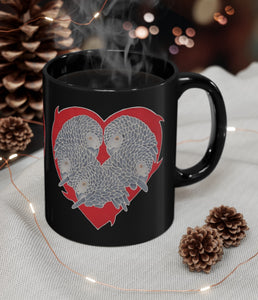A steaming mug of coffee in a mug printed with a design created by handpainted batik and now printed. Profiles of 5 African Grey parrots, just the heads & upper body, are arranged in a heart shape. A flaming red heart serves as the background for the CAGs.