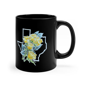 Black mug with a handpainted batik design (that is printed on the mug) of a bouquet of yellow roses with greenery set against the outline of the Texas border. The two sides of the mug have the design so it's visible whether you are right or left-handed.