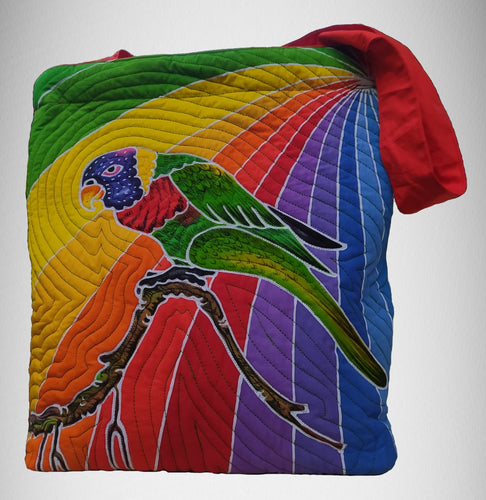 A eye-catching hand-painted batik tote-style bag featuring a Rainbow Lory set against a rainbow hue of colors.