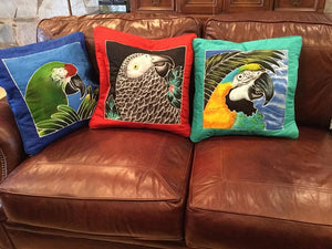 Blue & Gold macaw batik pillow cover stuffed and on a couch