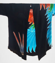 Front view of hand-painted batik Greenwing macaw parrot jacket. The right front panel has 3 feathers batiked towards the bottom.  Additional feathers flow over the shoulder and from the left side seam.
