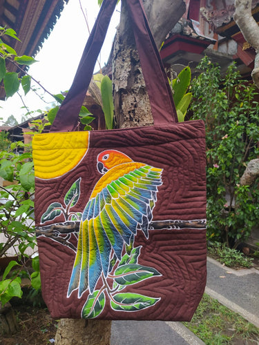 Sun Conures are gorgeous birds and we've tried to capture that in our hand-painted batik tote-style bag! The bird is stretching its left wing while perching, and a yellow sun is on the left-hand top corner.