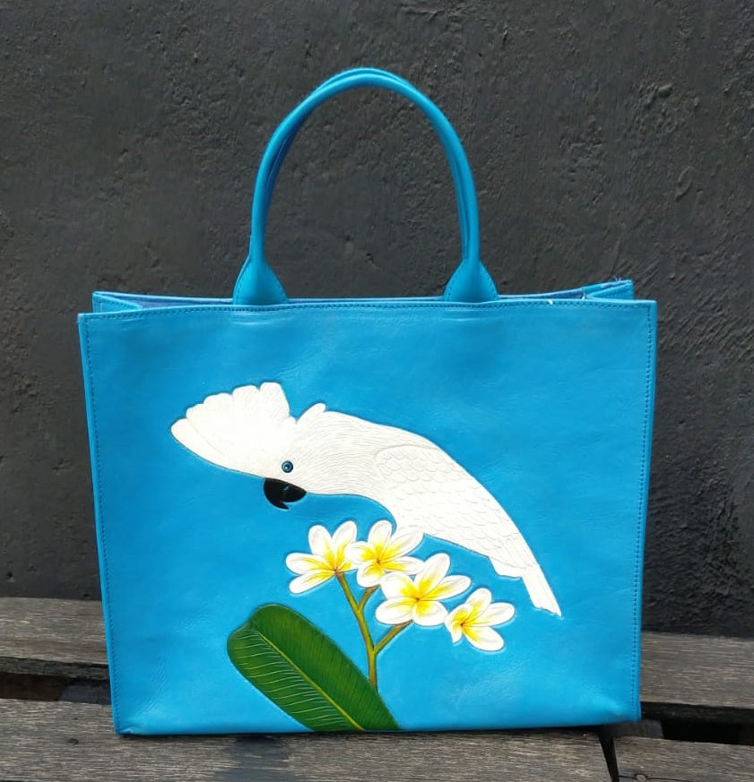 Hand-tooled, handpainted leather tote-style bag featuring a gorgeous Umbrella cockatoo standing on a spray of flowers